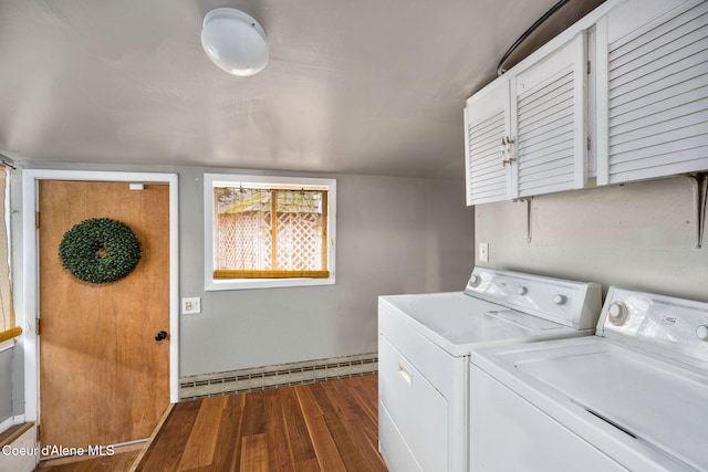 laundry room featuring dark wood-type flooring, baseboard heating, washer and clothes dryer, and cabinet space