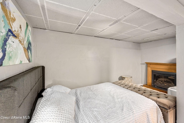 bedroom featuring a glass covered fireplace