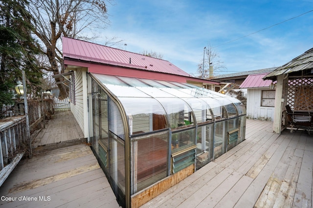 wooden terrace featuring an outbuilding and an exterior structure