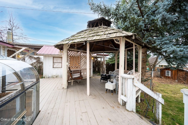 wooden deck featuring an outdoor structure, fence, and a gazebo