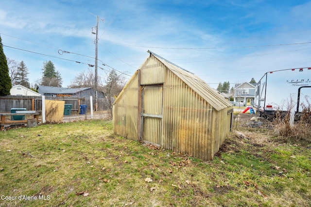 view of greenhouse with a lawn and fence