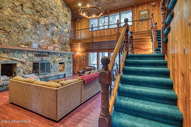 living room with wood walls, wood ceiling, a fireplace, and wood finished floors