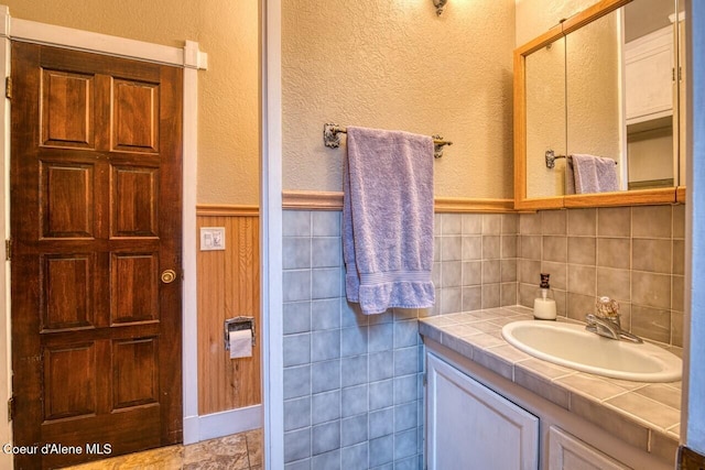 bathroom with a wainscoted wall and vanity