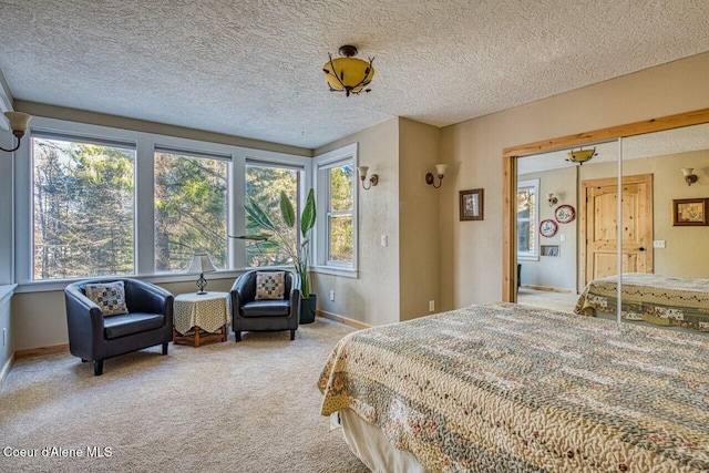 bedroom with carpet, a textured ceiling, and baseboards