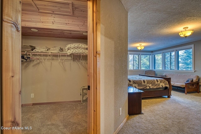 bedroom featuring carpet, a textured ceiling, and baseboards