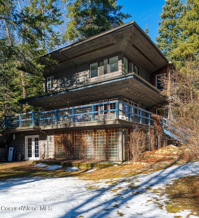 view of property exterior with french doors and a wooden deck