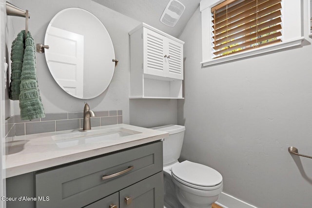 bathroom featuring visible vents, vanity, toilet, and baseboards