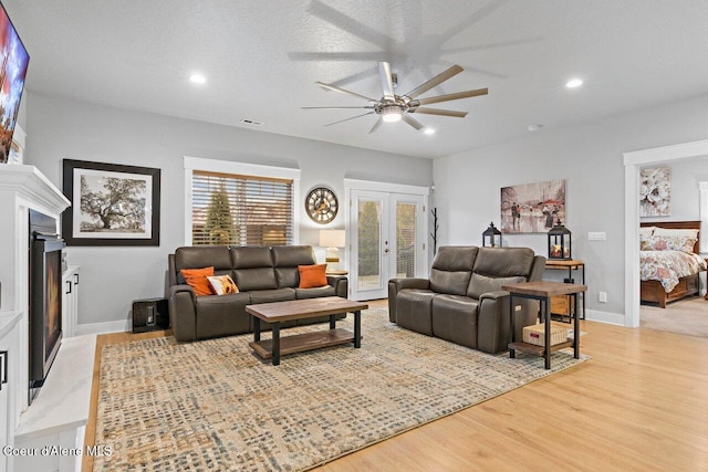 living room with baseboards, visible vents, wood finished floors, french doors, and recessed lighting