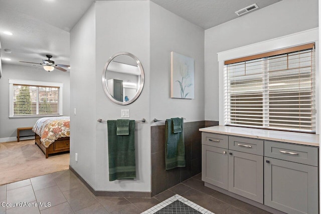 bathroom featuring tile patterned flooring, visible vents, ceiling fan, and a textured ceiling