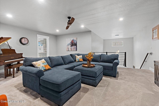 living area with recessed lighting, a textured ceiling, and light colored carpet