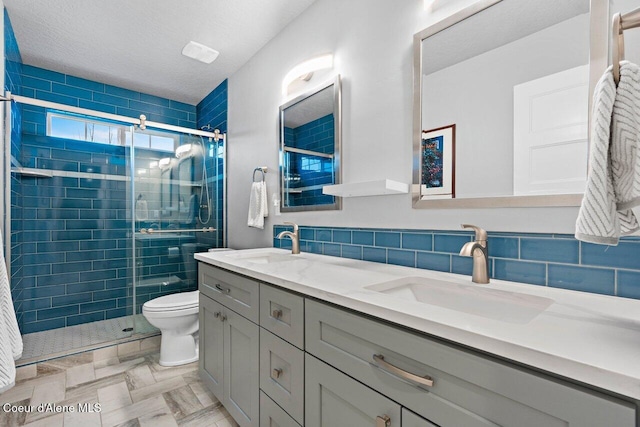 bathroom with double vanity, a stall shower, and a sink