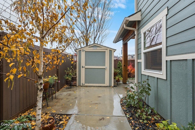 view of patio featuring a fenced backyard, an outdoor structure, and a storage shed