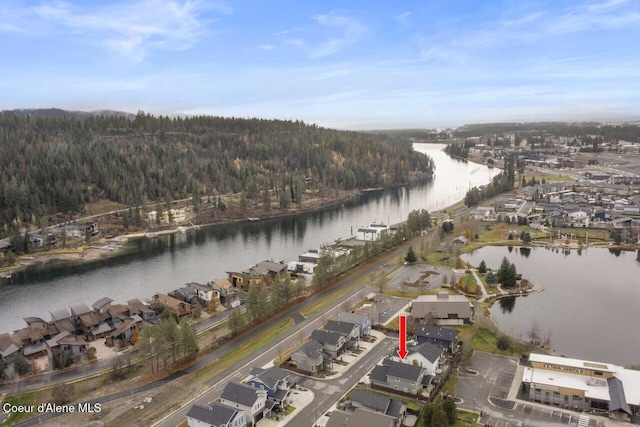 drone / aerial view with a forest view and a water view