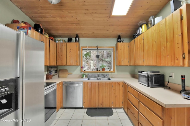 kitchen featuring light tile patterned floors, a sink, wood ceiling, light countertops, and appliances with stainless steel finishes