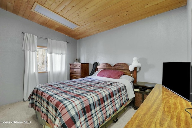 bedroom with wood ceiling, vaulted ceiling with skylight, and carpet floors