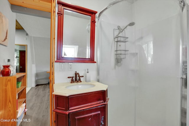 full bath featuring wood finished floors and a shower stall