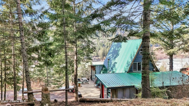 view of side of property with a deck and metal roof