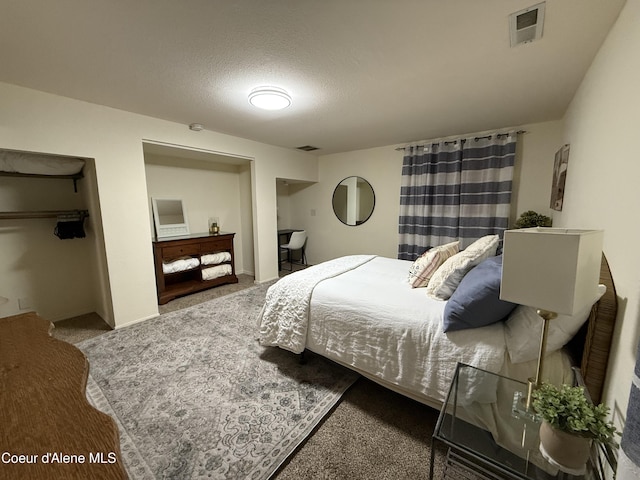 carpeted bedroom with visible vents and a textured ceiling