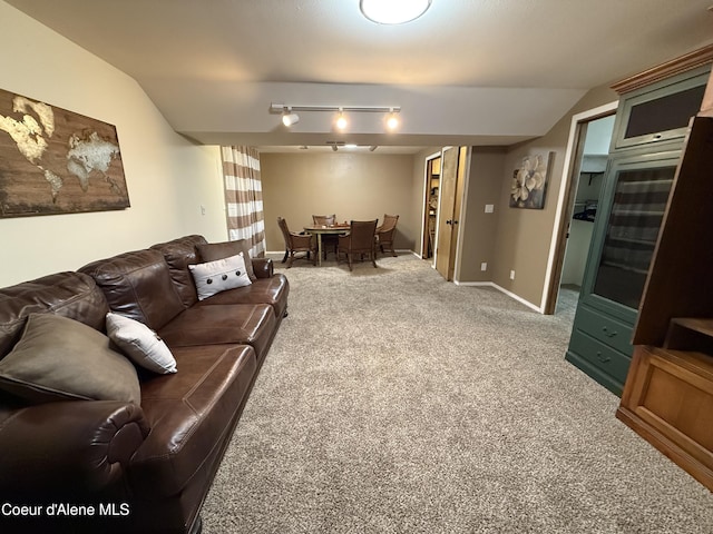 living room with carpet floors, lofted ceiling, track lighting, and baseboards