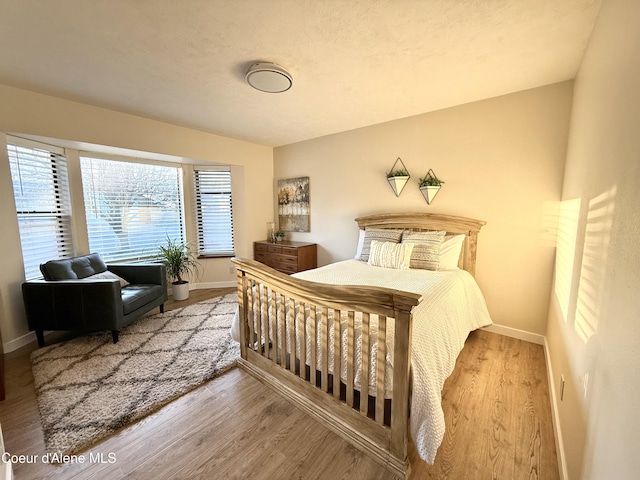 bedroom featuring baseboards and wood finished floors