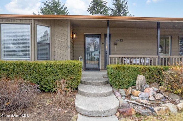 view of exterior entry featuring covered porch