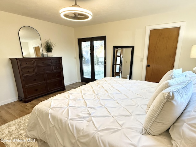 bedroom featuring access to exterior, baseboards, and dark wood-style flooring