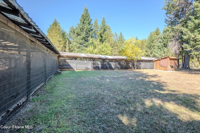 view of yard with an outbuilding, a storage shed, and a fenced backyard