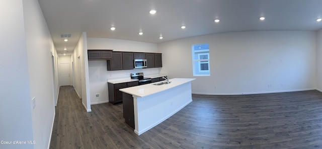 kitchen with dark wood finished floors, a center island with sink, stainless steel appliances, a sink, and dark brown cabinets