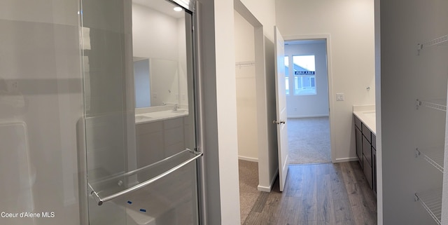 full bathroom featuring wood finished floors, vanity, and baseboards