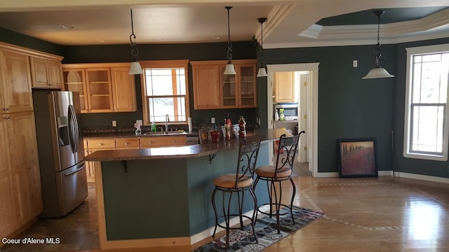 kitchen featuring plenty of natural light, a kitchen bar, glass insert cabinets, and stainless steel refrigerator with ice dispenser