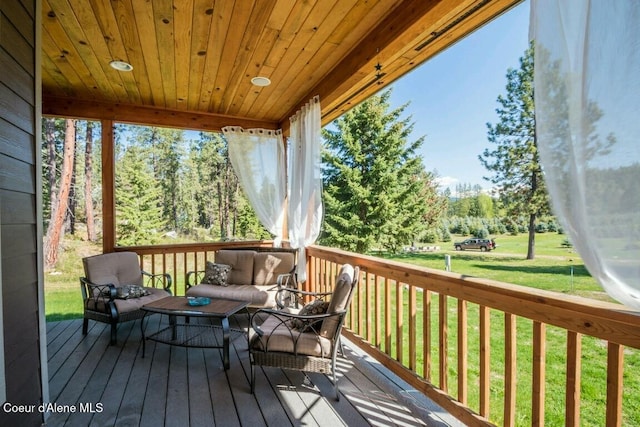 wooden terrace featuring a lawn and outdoor lounge area