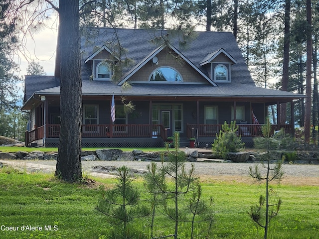 country-style home with a porch, driveway, a front lawn, and roof with shingles