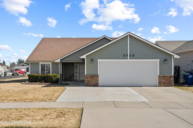 view of front of house with an attached garage, stone siding, driveway, and a shingled roof