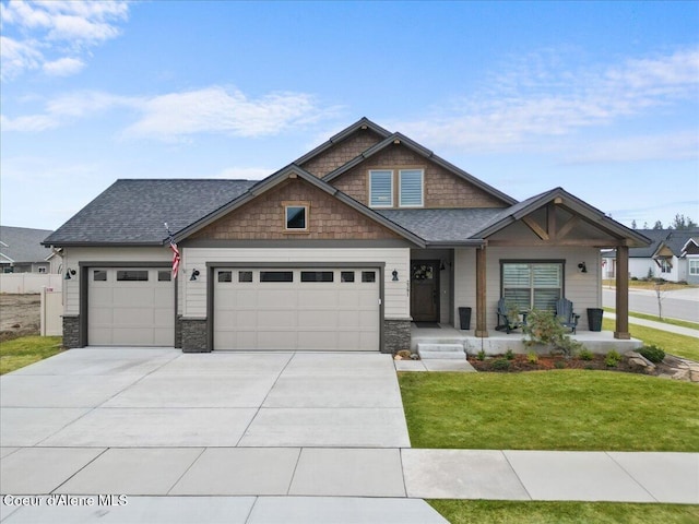 craftsman inspired home featuring a garage, a front yard, concrete driveway, and roof with shingles