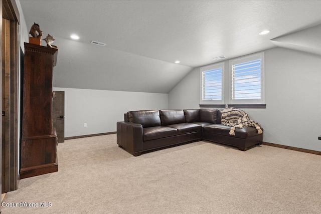 living room featuring visible vents, vaulted ceiling, light carpet, and baseboards