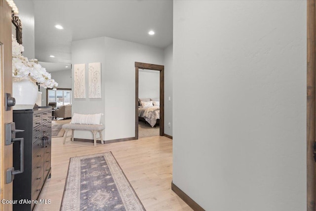 hall featuring light wood-style flooring, baseboards, and recessed lighting