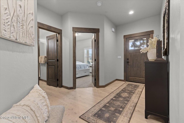 foyer entrance with recessed lighting, light wood-type flooring, and baseboards