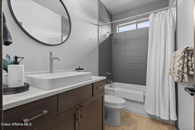 bathroom with shower / bath combo with shower curtain, vanity, toilet, and wood finished floors