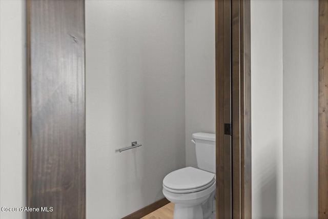 bathroom with toilet and wood finished floors