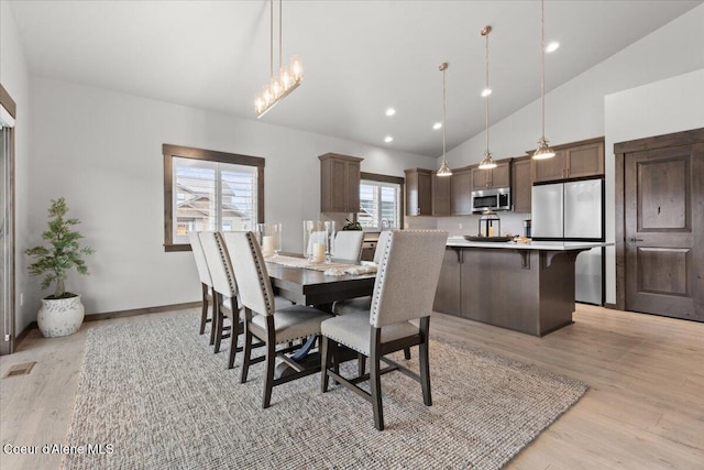 dining space with recessed lighting, visible vents, light wood-style flooring, high vaulted ceiling, and baseboards