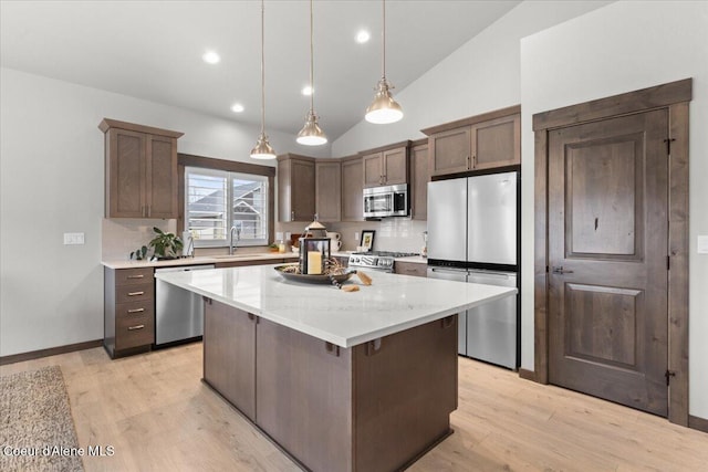 kitchen with decorative backsplash, stainless steel appliances, a sink, and a center island