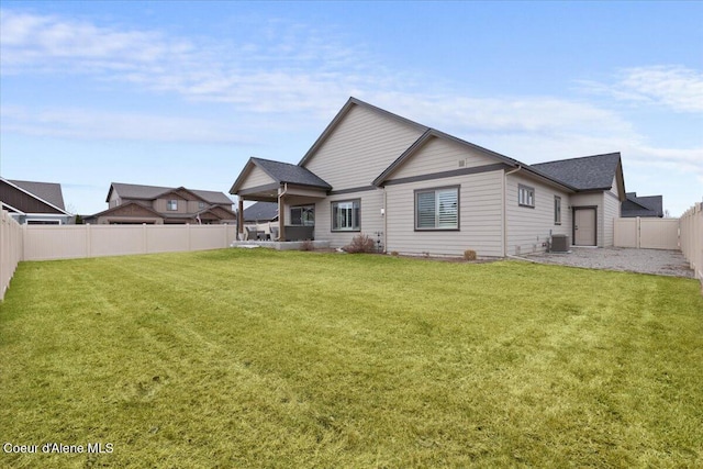 rear view of property with central AC unit, a lawn, and a fenced backyard