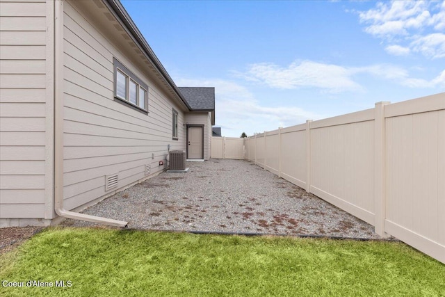 view of yard featuring a fenced backyard and central AC