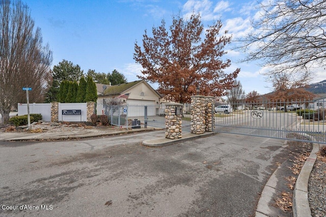 view of road featuring a gate, curbs, and a gated entry