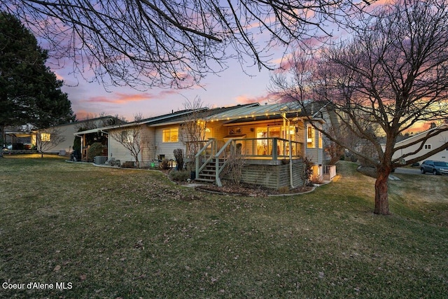 rear view of house with metal roof and a yard