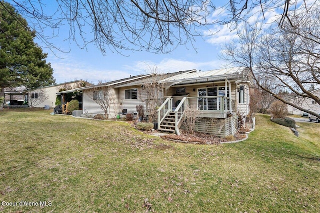 rear view of property featuring metal roof and a yard