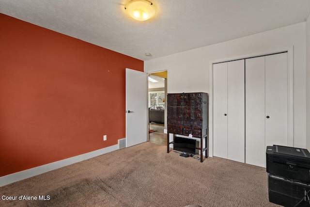 bedroom featuring a textured ceiling, a closet, carpet, and visible vents