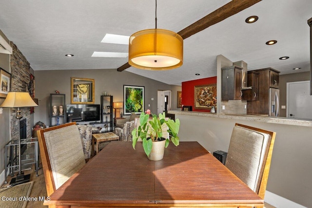 dining room featuring lofted ceiling with skylight and recessed lighting