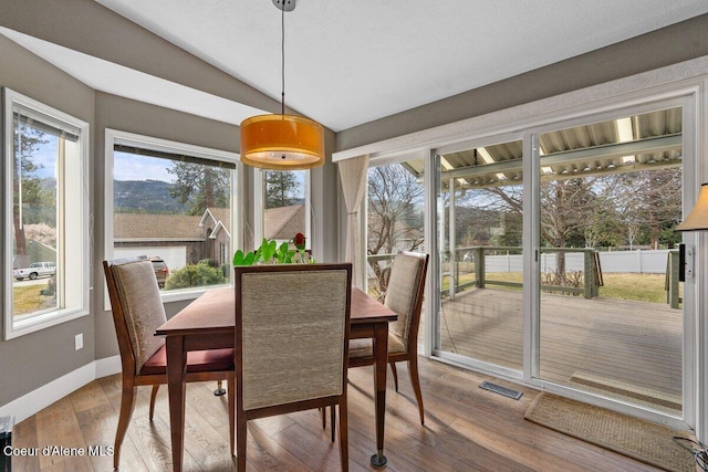 sunroom featuring vaulted ceiling, visible vents, and a healthy amount of sunlight