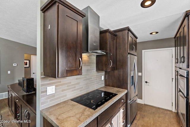 kitchen featuring tasteful backsplash, appliances with stainless steel finishes, dark brown cabinetry, wall chimney range hood, and baseboards